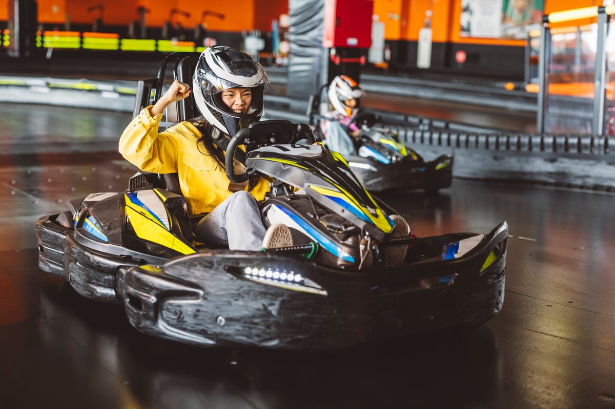 An excited racer throwing a fist in the air after overtaking a rival on the indoor circuit